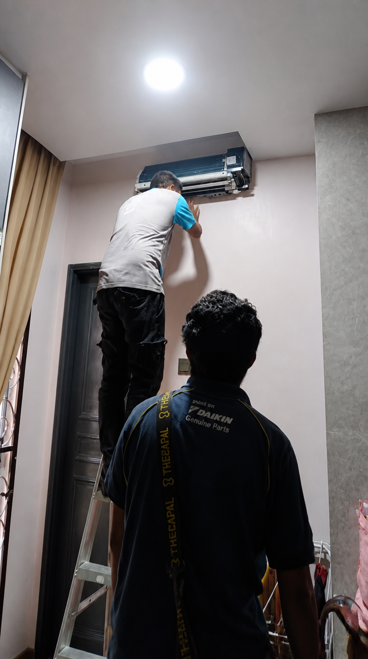 Technician servicing aircond on ladder photo